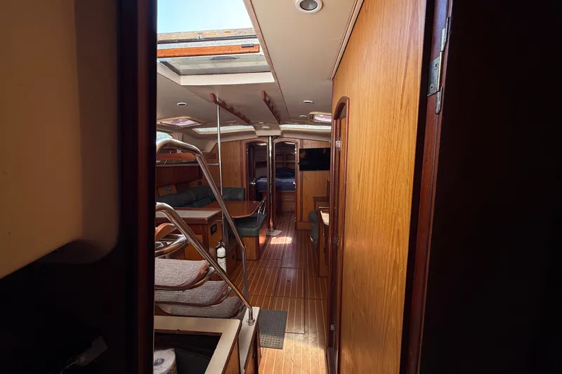 Slide: The Image of Interior of a 2000 Hunter 460 yacht with wooden finishes and seating area. - 26