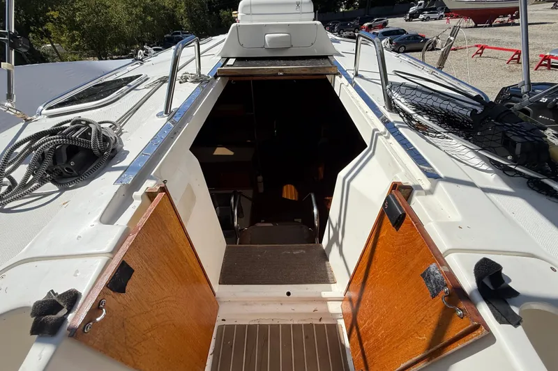 Slide: The Image of Hunter 460 sailboat cockpit entrance, featuring open wooden doors and deck equipment, year 2000 model. - 22
