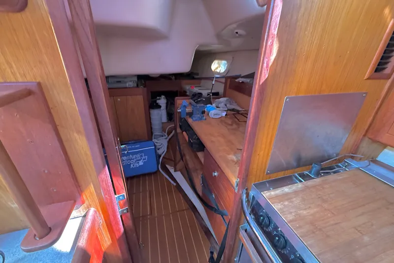 Slide: The Image of Interior of a 2000 Hunter 460 sailboat with wooden cabinetry and compact kitchen area. - 28