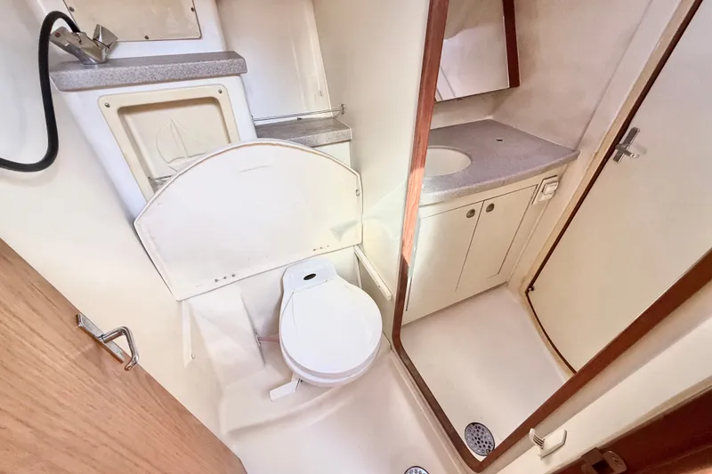 Slide: The Image of Compact bathroom in a 2000 Hunter 460 yacht, featuring a toilet, sink, and shower area. - 38