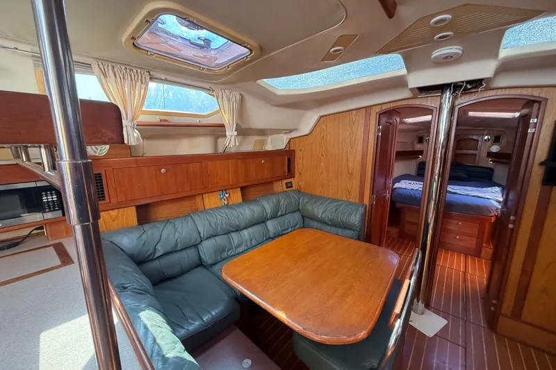 Slide: The Image of Interior of a 2000 Hunter 460 yacht with wood paneling and cozy seating area. - 50