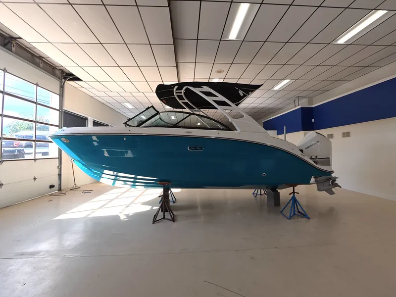 Slide: The Image of A 2026 Sea Ray SDX 230 Outboard is displayed on stands in a bright showroom. - 2