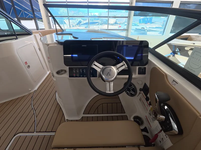 Slide: The Image of The cockpit of the Sea Ray SDX 230 Outboard features a modern steering wheel and digital dashboard. - 12