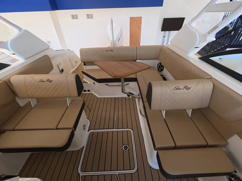 Slide: The Image of Interior of a Sea Ray SDX 230 Outboard with elegant beige upholstery and a wooden table. - 11