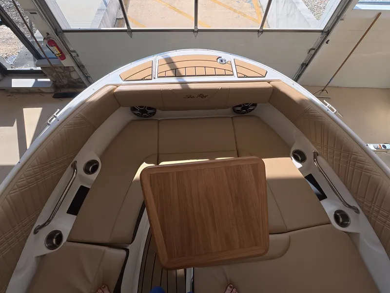 Slide: The Image of The image shows the bow of a Sea Ray SDX 230 Outboard with beige upholstery and a wooden table. - 21