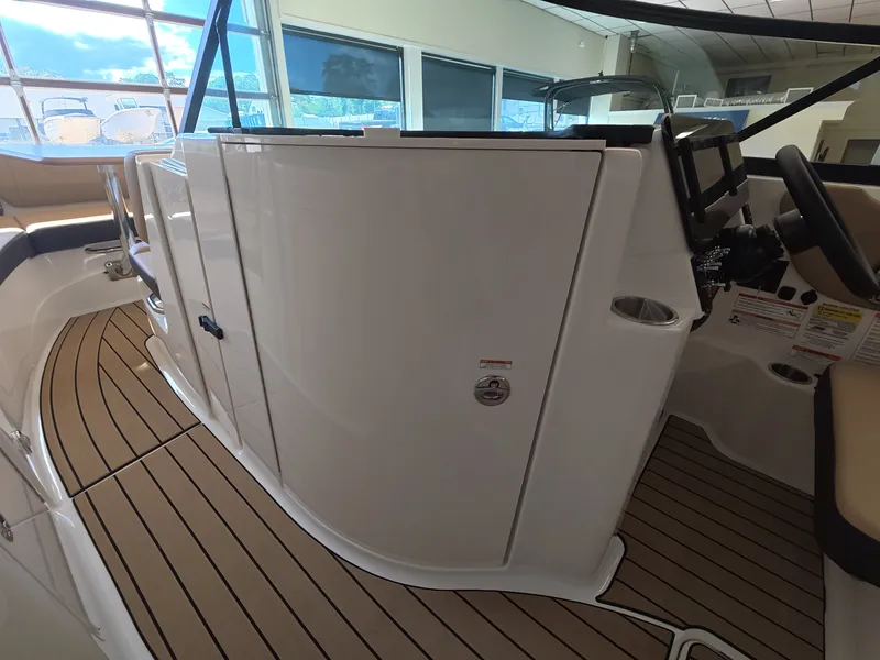 Slide: The Image of The image shows the cockpit of a 2026 Sea Ray SDX 230 Outboard with sleek wood flooring. - 15