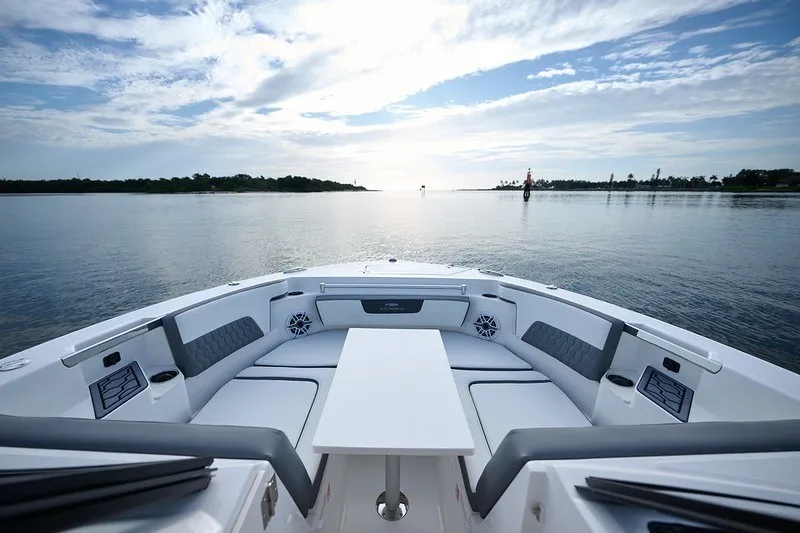 Slide: The Image of 2027 Cobia 250 Dual Console boat interior with seating and table on calm water. - 13