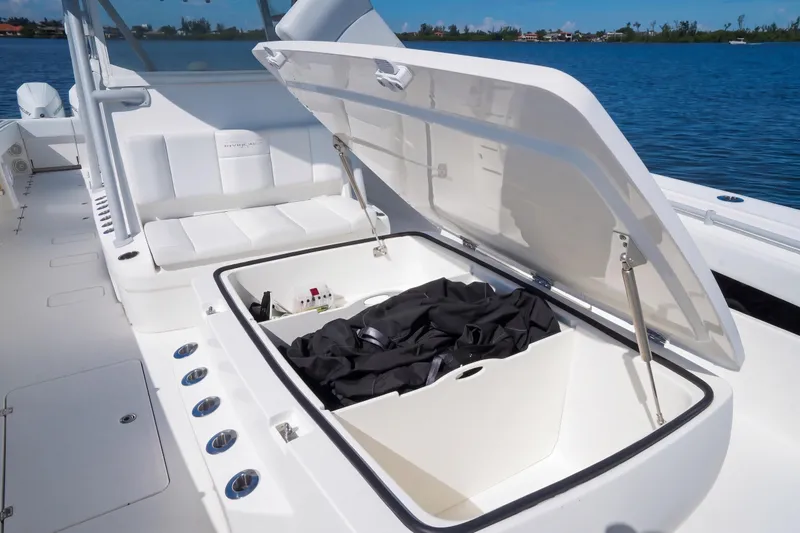 Slide: The Image of 2019 Invincible 37 Catamaran with open storage compartment on deck, near water. - 29