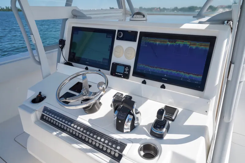Slide: The Image of Control panel of a 2019 Invincible 37 Catamaran with advanced navigation displays and steering wheel. - 20