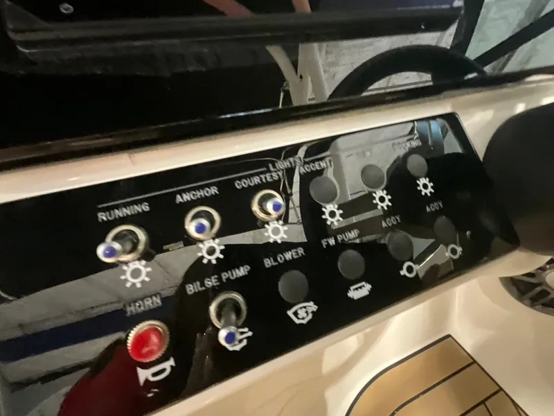Slide: The Image of Close-up of a Sea Ray SDX 230 Outboard control panel with various switches and indicators. - 21