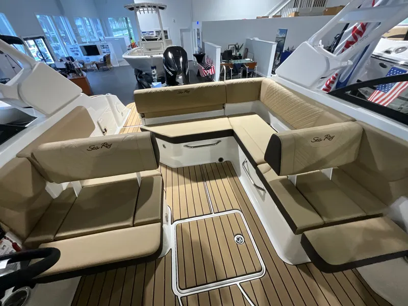 Slide: The Image of Interior of the Sea Ray SDX 230 Outboard with beige upholstery and wood flooring. - 13