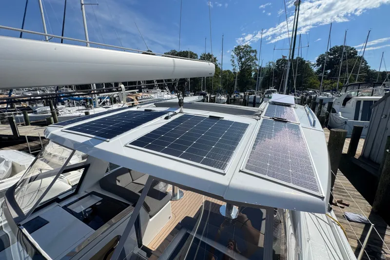 Slide: The Image of 2025 Hanse 460 yacht with solar panels docked at a marina under clear skies. - 10