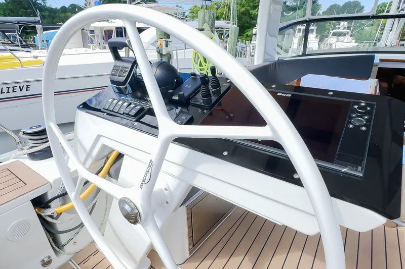 Slide: The Image of Steering wheel and control panel of 2025 Hanse 460 yacht, docked at marina. - 8