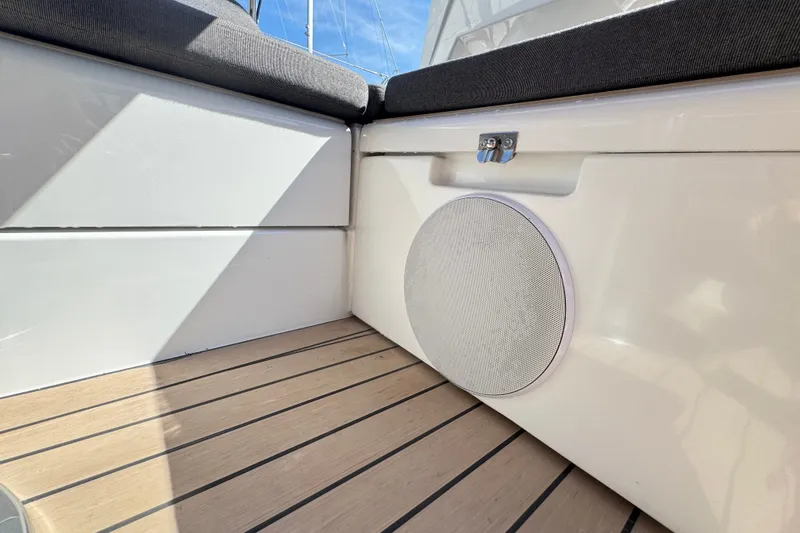 Slide: The Image of 2025 Hanse 460 yacht interior with cushioned seating and integrated speaker on wooden deck. - 12