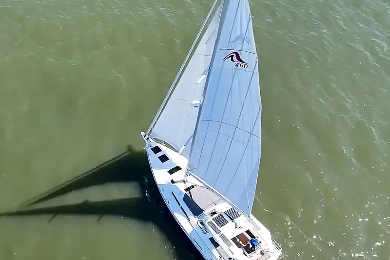 Slide: The Image of Aerial view of 2025 Hanse 460 sailboat gliding on green water. - 3