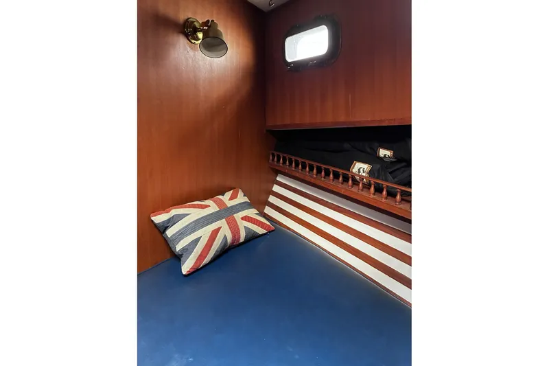 Slide: The Image of 1979 Ocean Alexander 40 Double Cabin interior with Union Jack pillow, wooden walls, and nautical decor. - 42