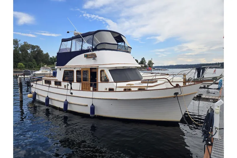 Slide: The Image of 1979 Ocean Alexander 40 Double Cabin yacht docked on a serene lake. - 2