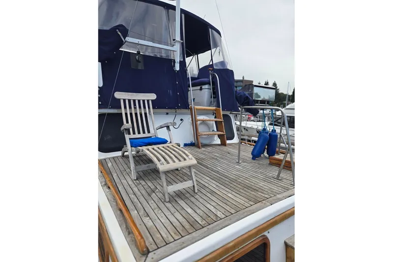 Slide: The Image of 1979 Ocean Alexander 40 Double Cabin yacht deck with wooden chair and blue cushions. - 57