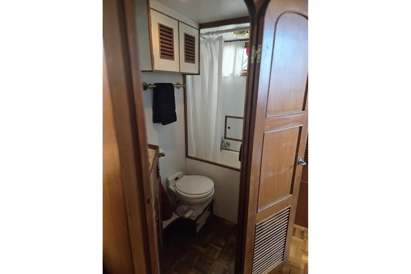 Slide: The Image of 1979 Ocean Alexander 40 Double Cabin bathroom with wooden cabinetry and shower curtain. - 36