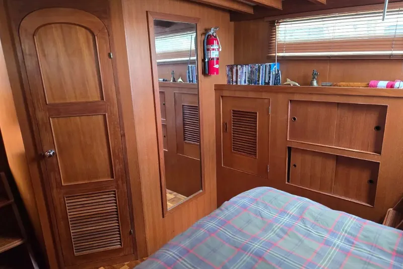 Slide: The Image of 1979 Ocean Alexander 40 Double Cabin interior with wood paneling and plaid bedding. - 34