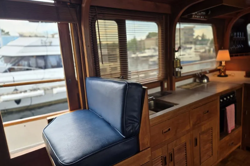Slide: The Image of Interior of 1979 Ocean Alexander 40 Double Cabin with wooden cabinetry and blue seating. - 24