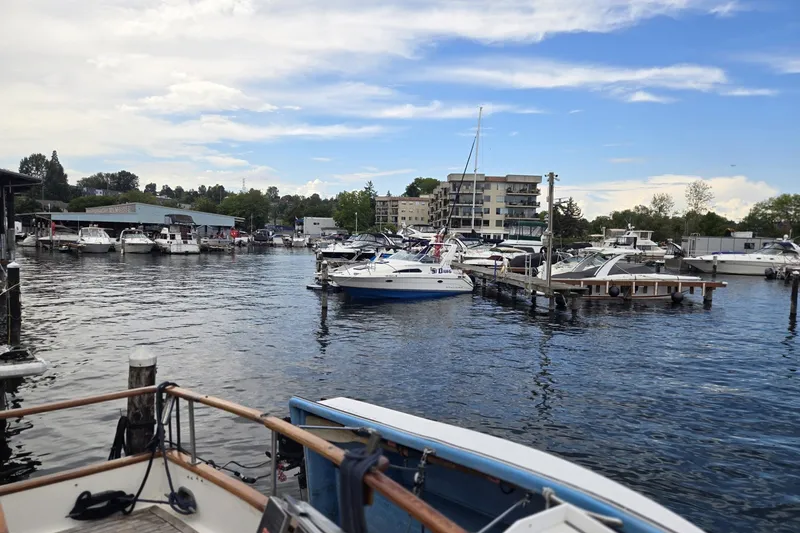 Slide: The Image of Marina with various boats, including a 1979 Ocean Alexander 40 Double Cabin, under a partly cloudy sky. - 55