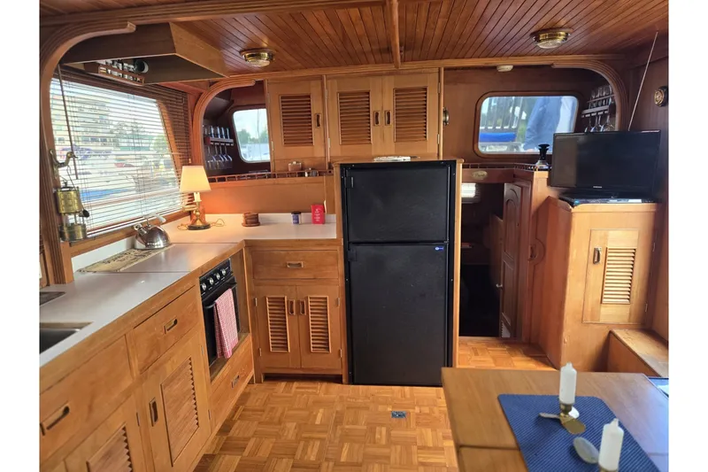 Slide: The Image of 1979 Ocean Alexander 40 Double Cabin interior with wooden cabinetry and modern appliances. - 26