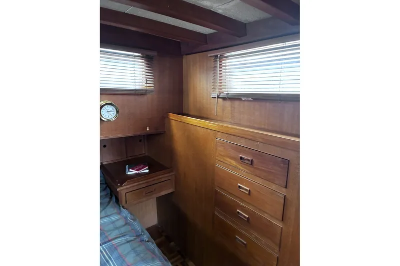 Slide: The Image of 1979 Ocean Alexander 40 Double Cabin interior with wood paneling, drawers, and a small desk. - 40