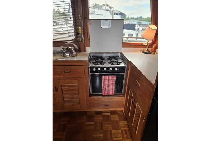 Slide: The Image of 1979 Ocean Alexander 40 Double Cabin kitchen with stove, kettle, and lamp. - 28