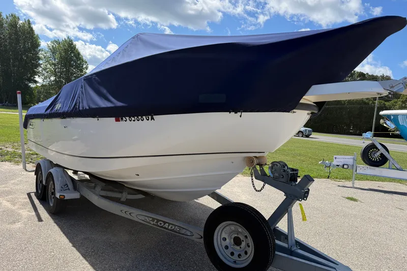 Slide: The Image of 2000 Boston Whaler 21 Outrage boat on trailer, covered, parked outdoors. - 17