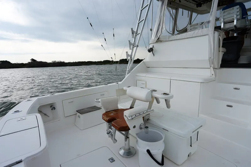 Slide: The Image of The image shows the stern of a 1999 Ocean Yachts 40 Super Sport. There are fishing rod holders and seating. - 13
