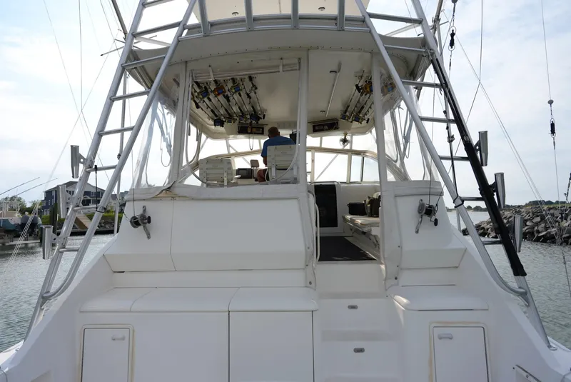 Slide: The Image of Rear view of a 1999 Ocean Yachts 40 Super Sport, featuring a spacious cockpit and fishing rod holders. - 14