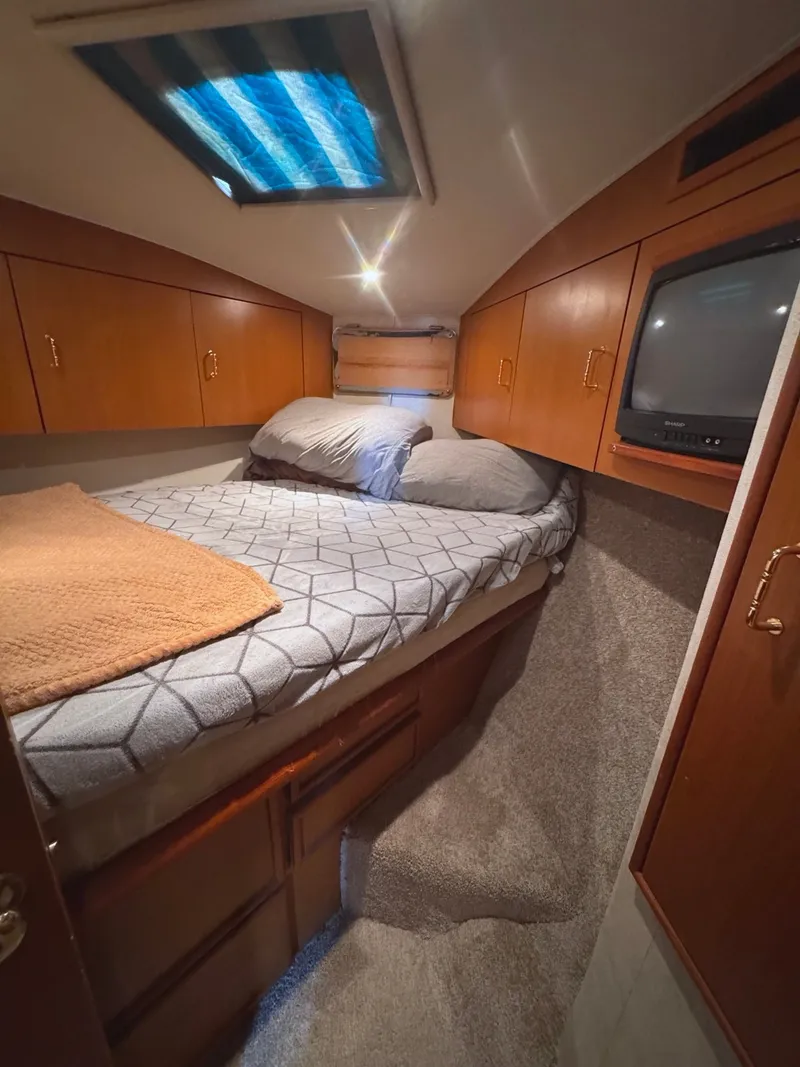 Slide: The Image of Cabin of the 1999 Ocean Yachts 40 Super Sport with cozy bed and storage. - 26