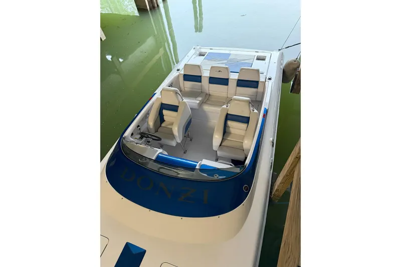 Slide: The Image of 2008 Donzi 27 ZR speedboat with blue and white seating, docked in calm water. - 23