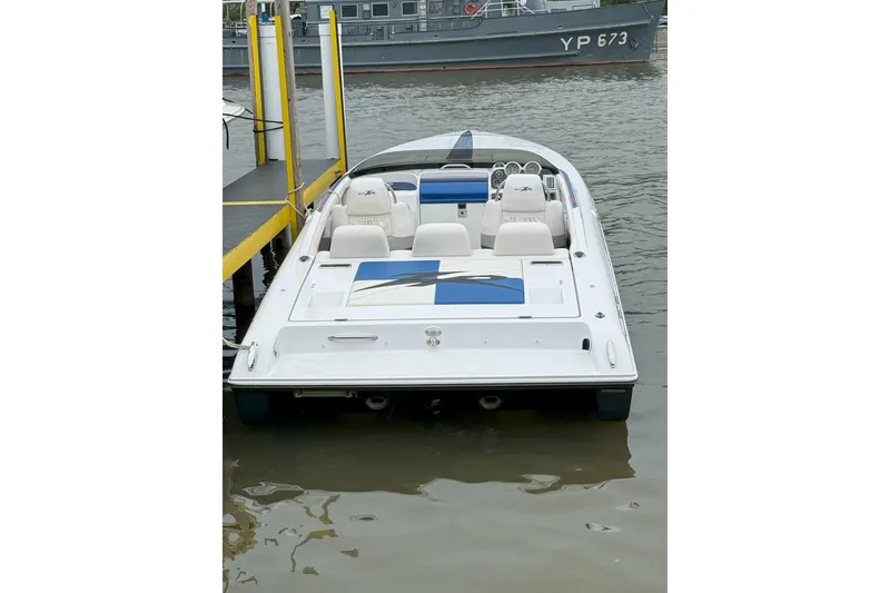 Slide: The Image of 2008 Donzi 27 ZR speedboat docked, featuring sleek design and white-blue seating. - 22