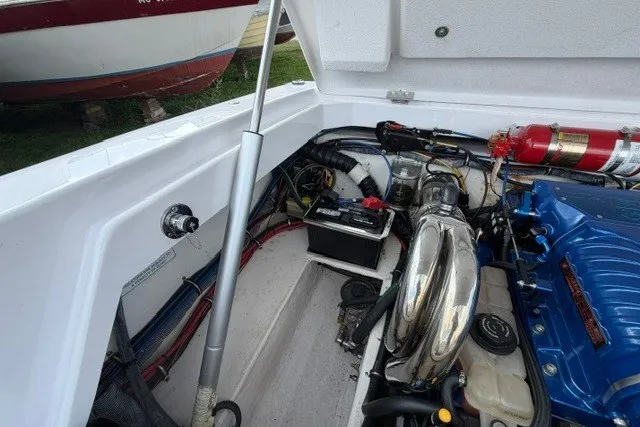 Slide: The Image of Engine compartment of a 2008 Donzi 27 ZR boat, featuring a blue engine and fire extinguisher. - 19