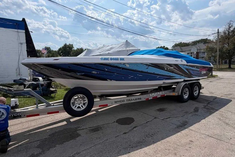 The Image of 2008 Donzi 27 ZR speedboat on a Myco trailer, covered and parked outdoors. - 0