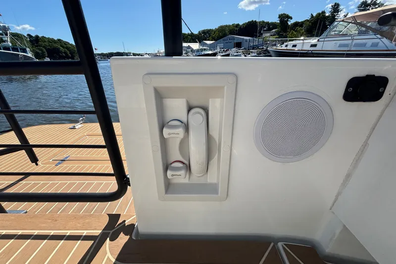 Slide: The Image of 2024 Targa 32 boat deck with water controls and speaker, docked at marina. - 57