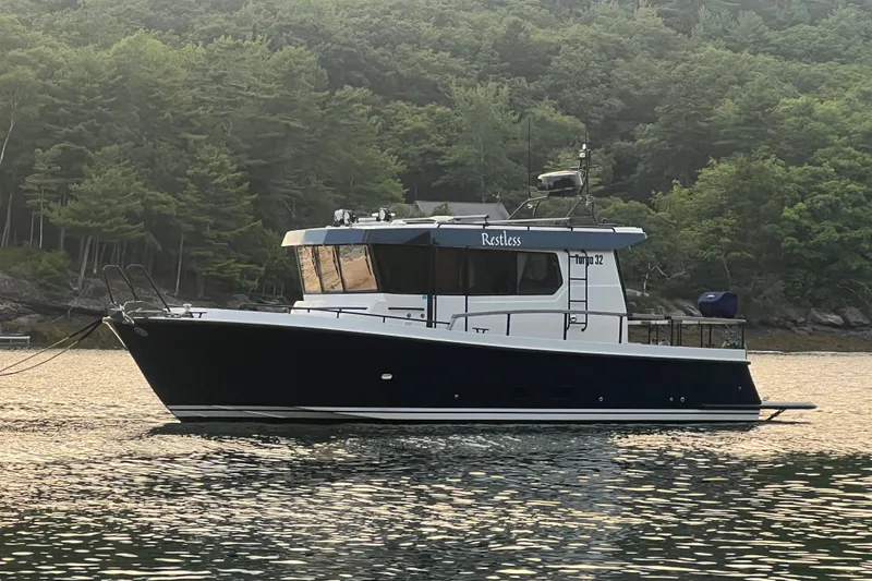 Slide: The Image of 2024 Targa 32 boat on calm water with forested background. - 3