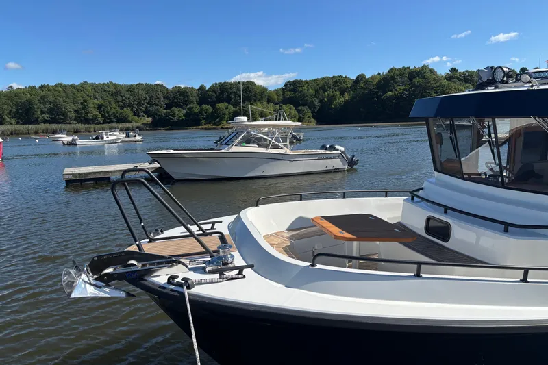 Slide: The Image of 2024 Targa 32 boat docked on a serene lake with lush green trees. - 19