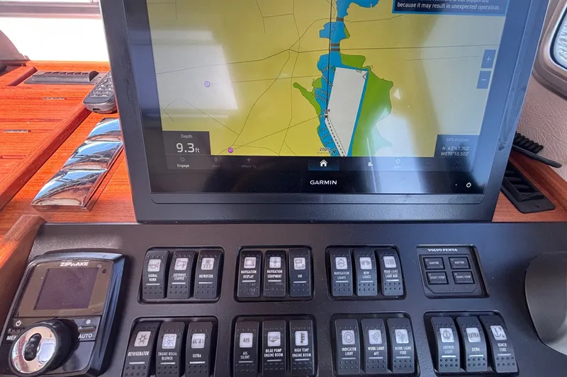 Slide: The Image of Garmin navigation display and control panel on 2024 Targa 32 boat dashboard. - 38