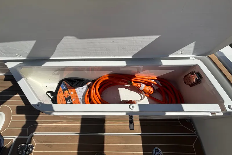 Slide: The Image of Storage compartment on 2024 Targa 32 boat with orange extension cord. - 56