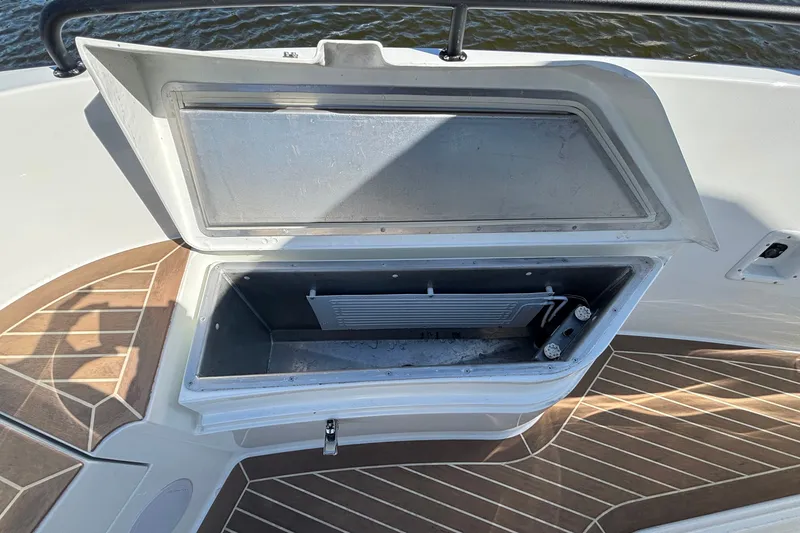 Slide: The Image of Open storage compartment on 2024 Targa 32 boat with wooden deck flooring. - 53