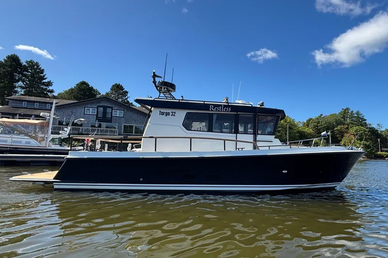 Slide: The Image of 2024 Targa 32 boat on calm water under clear blue sky. - 12