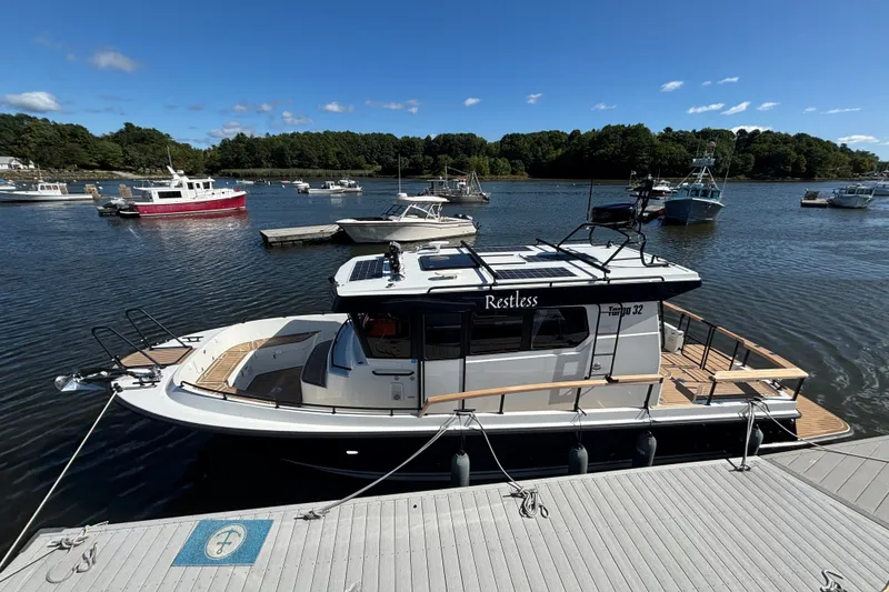 Slide: The Image of 2024 Targa 32 boat docked in a scenic marina under a clear blue sky. - 10