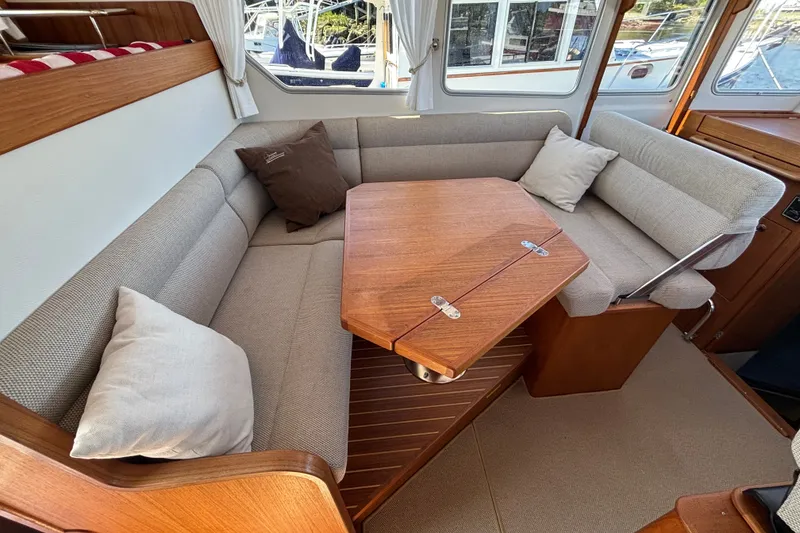 Slide: The Image of Cozy interior of 2024 Targa 32 boat with cushioned seating and wooden table. - 27