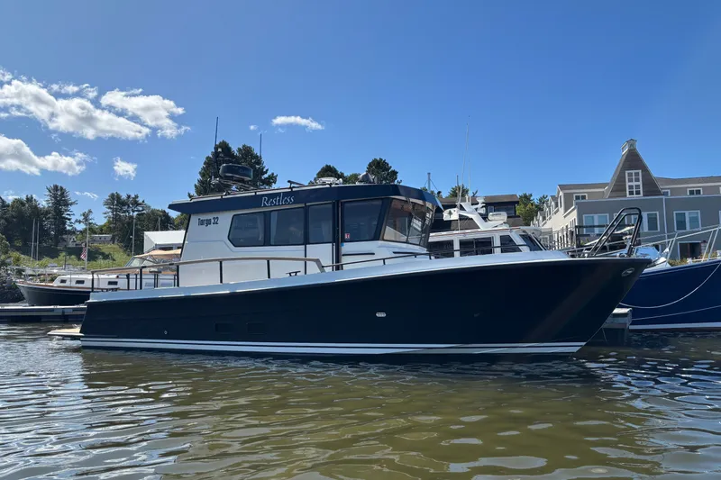 Slide: The Image of 2024 Targa 32 boat docked in a marina under a clear blue sky. - 7
