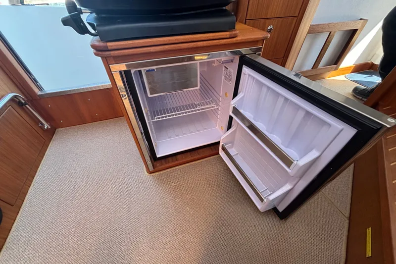 Slide: The Image of Open refrigerator inside 2024 Targa 32 boat, showcasing interior storage space. - 34