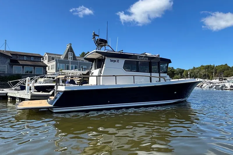 Slide: The Image of 2024 Targa 32 boat docked at a marina under a clear blue sky. - 13