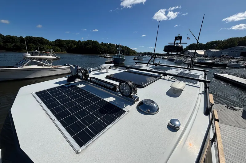 Slide: The Image of 2024 Targa 32 boat with solar panels docked at a marina under clear skies. - 67